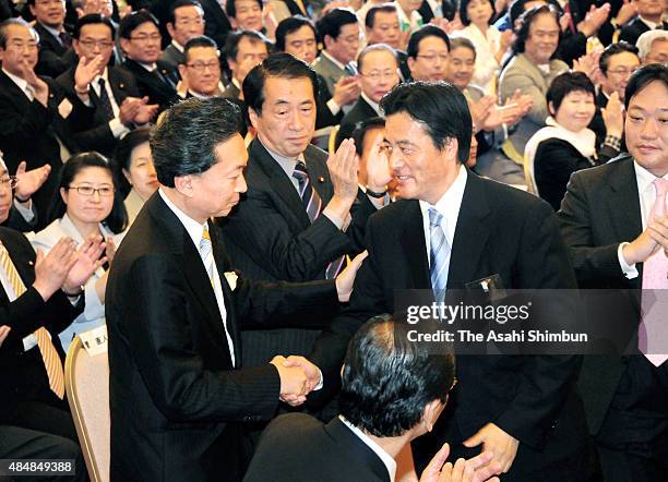 Newly elected opposition Democratic Party of Japan president Yukio Hatoyama shakes hands with defeated candidate Katsuya Okada after vote counting on...