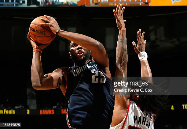 Al Jefferson of the Charlotte Bobcats grabs a rebound against Cartier Martin of the Atlanta Hawks at Philips Arena on April 14, 2014 in Atlanta,...