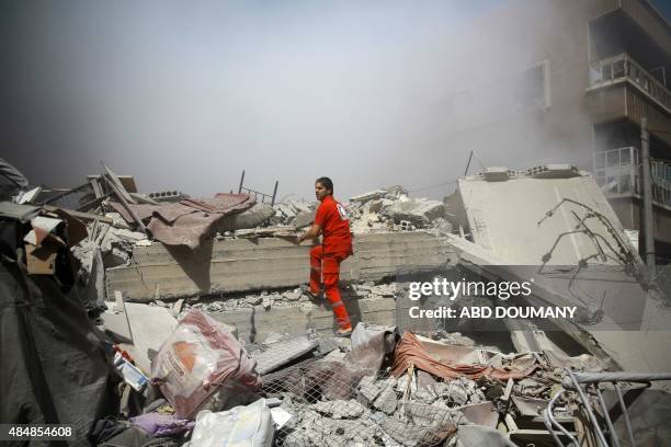 Member of the Syrian Red Crescent inspect rubble searching for victims in the rebel-held area of Douma, east of the capital Damascus, following...