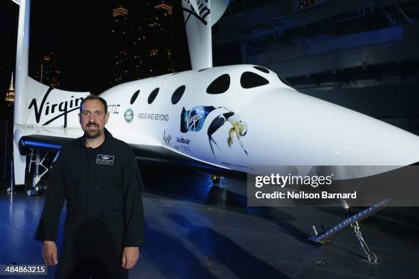 Pilot Michael Masucci poses with a large replica of SpaceShipTwo, Virgin Galactic's spaceship that will be used for commercial spaceline, at the...