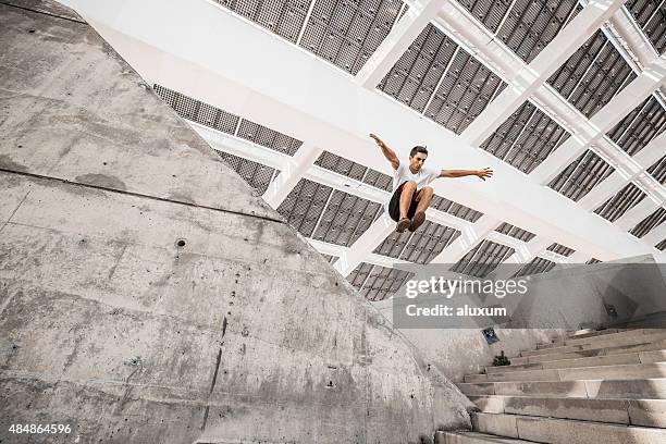 homme de parkour saut en ville - saut et lancer d'athlétisme masculin photos et images de collection