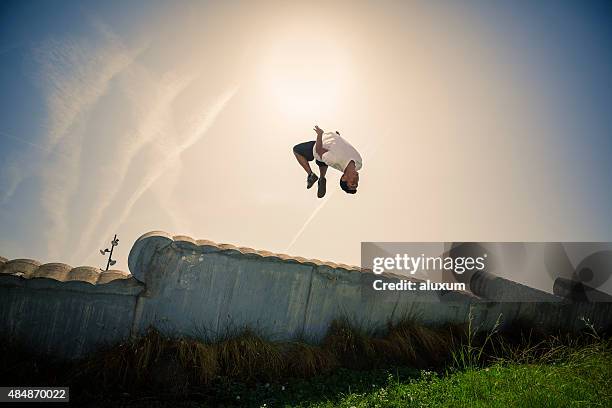 uomo di parkour in città facendo un fare le capriole all'indietro - fare le capriole all'indietro foto e immagini stock