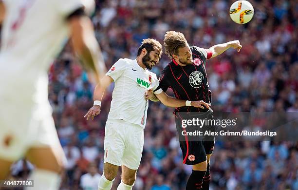 Halil Altintop of Augsburg jumps for a header with Marco Russ of Frankfurt during the Bundesliga match between Eintracht Frankfurt and FC Augsburg at...