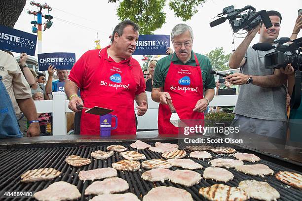 Republican presidential candidate New Jersey Governor Chris Christie and Iowa Governor Terry Branstad help to cook pork at the Iowa Pork Producers...