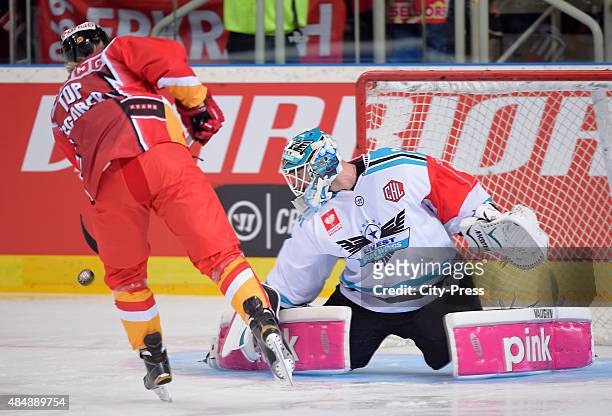 Ken Andre Olimb of the Duesseldorfer EG shoots the puck against Michael Ouzas of the Black Wings Linz during the game between Duesseldorfer EG and...