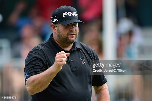Jason Gore reacts after making his birdie putt on the 18th green during the third round of the Wyndham Championship at Sedgefield Country Club on...