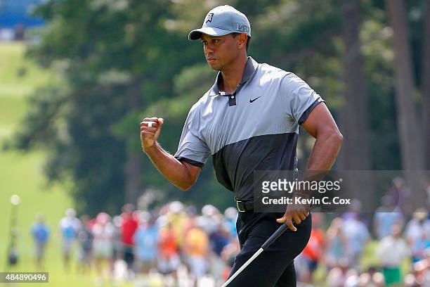 Tiger Woods reacts after making his par putt on the 10th hole during the third round of the Wyndham Championship at Sedgefield Country Club on August...