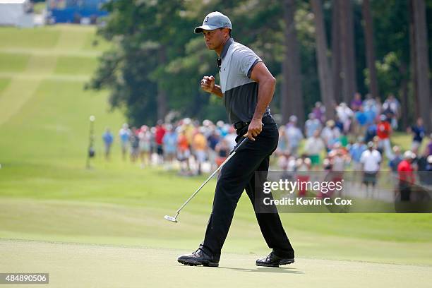 Tiger Woods reacts after making his par putt on the 10th hole during the third round of the Wyndham Championship at Sedgefield Country Club on August...