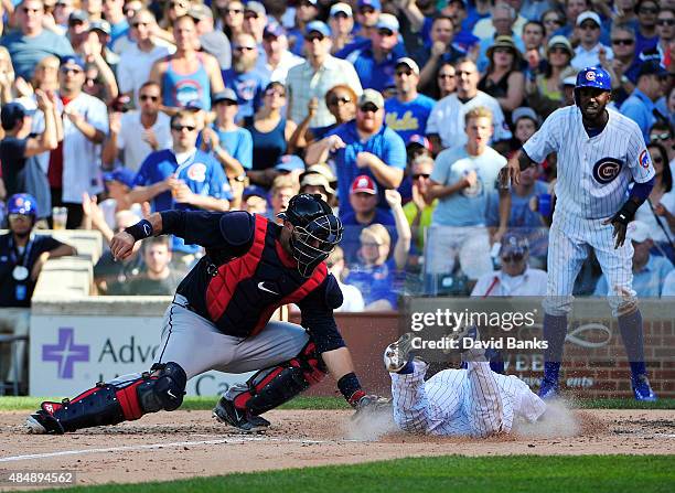 Chris Coghlan of the Chicago Cubs is safe at home plate as A.J. Pierzynski of the Atlanta Braves makes a late tag during the fifth inning on August...