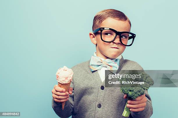 young nerd boy hates eating broccoli - negative emotion stock pictures, royalty-free photos & images