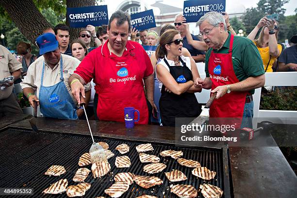 Chris Christie, governor of New Jersey and 2016 Republican presidential candidate, second from left, works the grill at the Iowa Pork Producers tent...