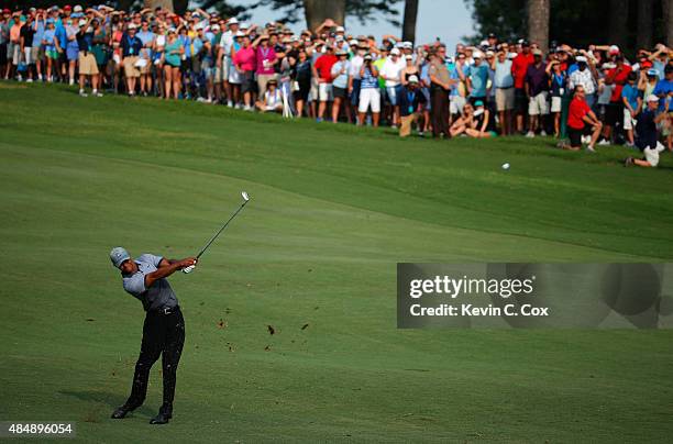 Tiger Woods plays his second shot on the 18th hole during the third round of the Wyndham Championship at Sedgefield Country Club on August 22, 2015...