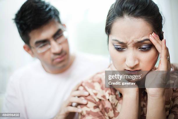 woman holding head with depression and headache, man consoling. - relationship issues stock pictures, royalty-free photos & images