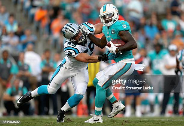 Luke Kuechly of the Carolina Panthers tackles Jarvis Landry of the Miami Dolphins during their game at Bank of America Stadium on August 22, 2015 in...