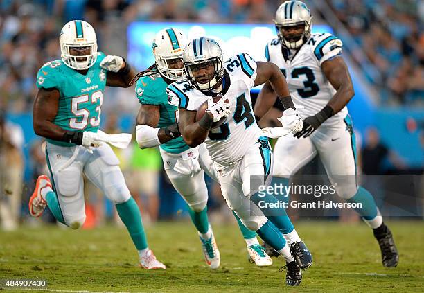 Cameron Artis-Payne of the Carolina Panthers runs against the Miami Dolphins during their preseason NFL game at Bank of America Stadium on August 22,...
