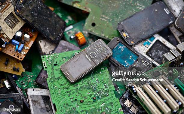 Old mobile phones lie between electronic components including circuit boards sit in a pile ahead of recycling at Aurubis AG metal refinery on...