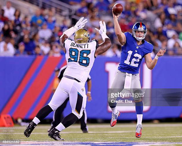 Ryan Nassib of the New York Giants passes under pressure from Michael Bennett of the Jacksonville Jaguars in the second half of preseason action at...