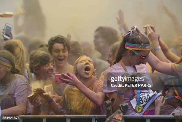 Girl reacts after getting yellow powder in her eys as people participate in the annual Color Run after party in Centennial Park in Sydney on August...