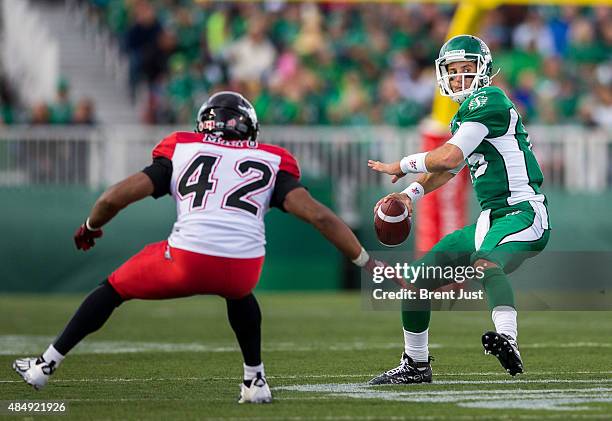 Brett Smith of the Saskatchewan Roughriders winds up for a deep pass in front of Deron Mayo of the Calgary Stampeders in a game between the Calgary...