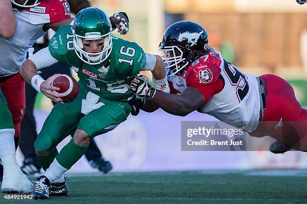 Brett Smith of the Saskatchewan Roughriders tries to escape the tackle of Derek Wiggan of the Calgary Stampeders in a game between the Calgary...