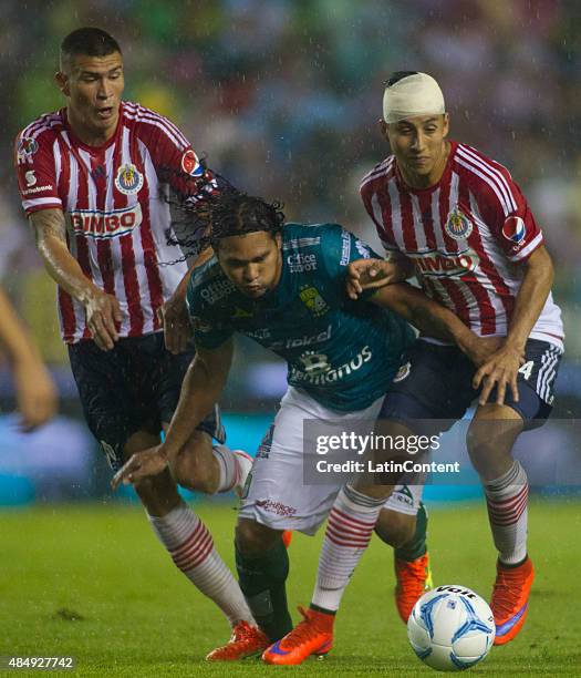 Carlos Peña of Leon fights for the ball with Carlos Cisneros and Jorge Enriquez of Chivas during a 6th round match between Leon and Chvias as part of...