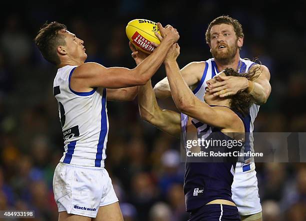 Nat Fyfe of the Dockers is challenged by Ben Jacobs and Lachlan Hansen of the Kangaros during the round 21 AFL match between the North Melbourne...