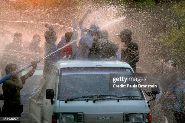 Burmese celebrate as water is sprayed during the third day of the Burmese new year water festival called Thingyan in Yangon, Myanmar April 15, 2014....