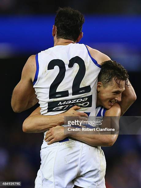 Todd Goldstein and Ben Jacobs of the Kangaroos celebrate after the Kangaroos defeated the Dockers during the round 21 AFL match between the North...