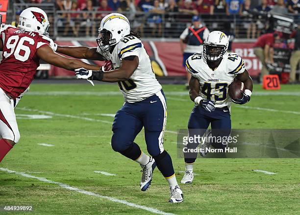 Branden Oliver of the San Diego Chargers runs the ball behind teammate David Johnson against the Arizona Cardinals during the second quarter at...