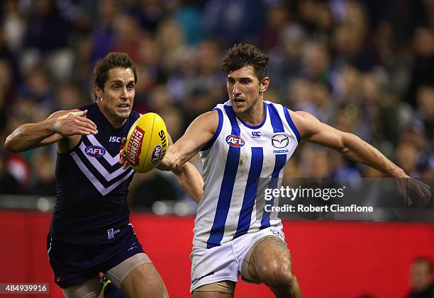 Jarrad Waite of the Kangaroos gets to the ball ahead of Luke McPharlin of the Dockers during the round 21 AFL match between the North Melbourne...