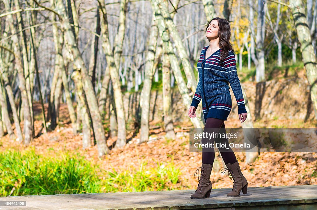 Giovane ragazza cammina per la foresta di alberi copia-spazio