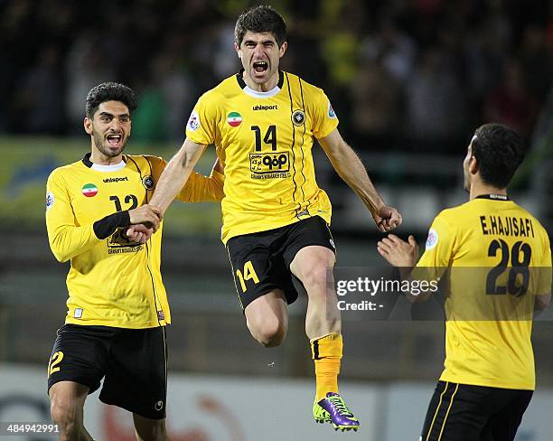 Iran's Sepahan forward Xhevahir Sukaj and his teammates Ali Karimi and Ehsan Hajisafi celebrate after scoring a goal against Qatar's Al-Sadd during...