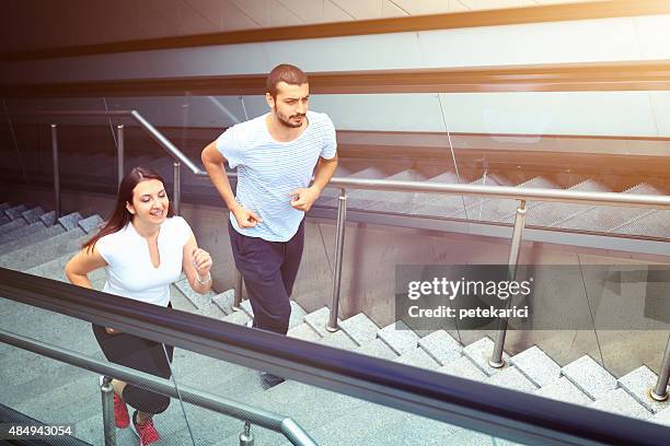 young couple jogging in istanbul - running up an escalator stock pictures, royalty-free photos & images