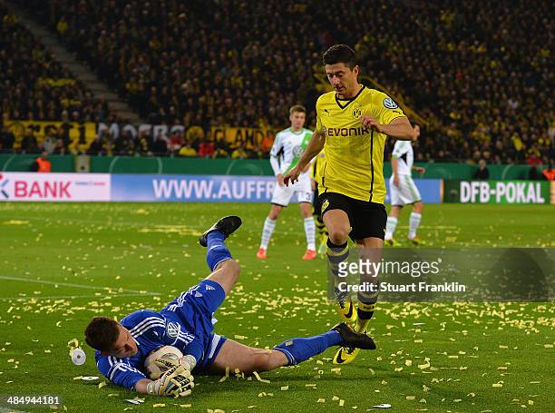 Robert Lewandowski of Dortmund is challenged by Max Grün of Wolfsburg during the DFB Cup semi final match between Borussia Dortmund and VfL Wolfsburg...