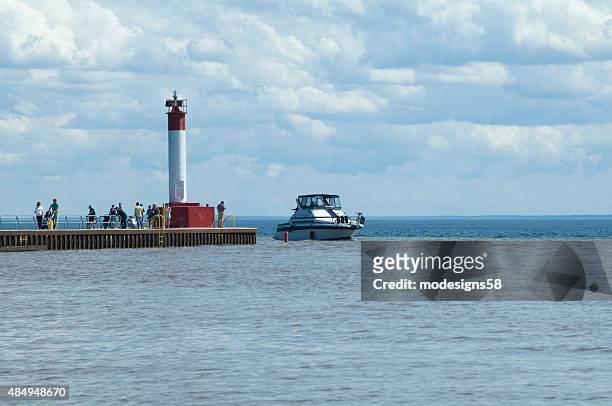 people on pier watching a boat arriving into oakville harbour - lake ontario stock pictures, royalty-free photos & images