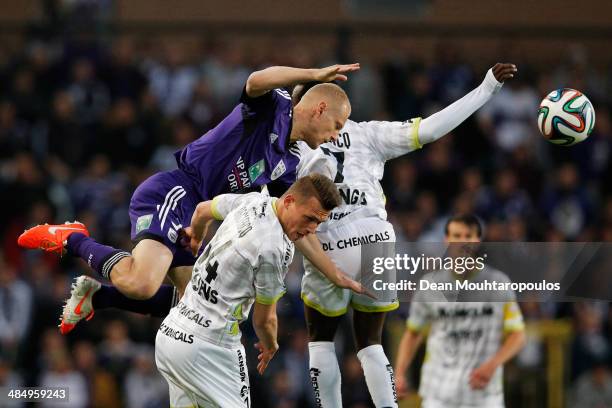 Olivier Deschacht of Anderlecht and Jens Naessens and Fabrice Olinga of Zulte battle for the header during the Jupiler Pro League match between RSC...