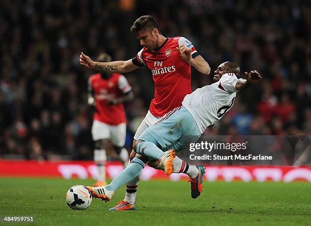 Olivier Giroud of Arsenal challenged by Pablo Armero of West Ham during the Barclays Premier League match between Arsenal and West Ham United at...