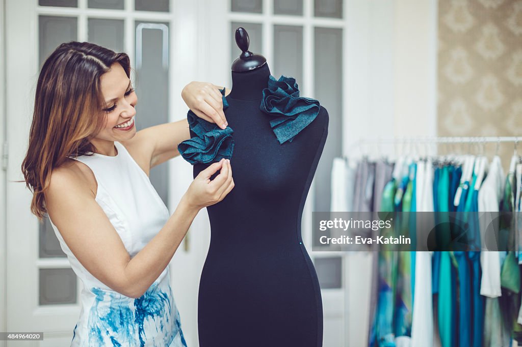 Young fashion designer is working in her showroom
