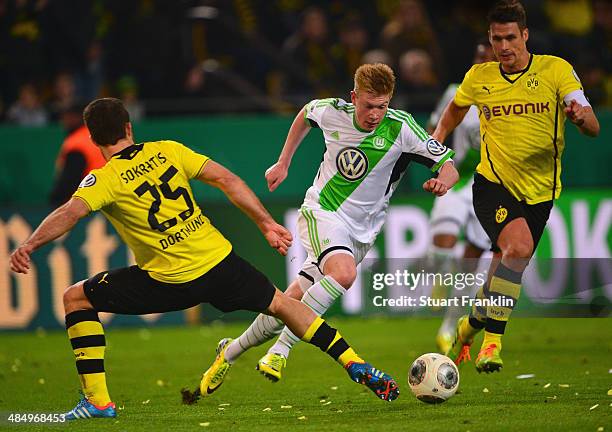 Sokratis Papastathopoulos of Dortmund is challenged by Kevin De Bruyne of Wolfsburg during the DFB Cup semi final match between Borussia Dortmund and...