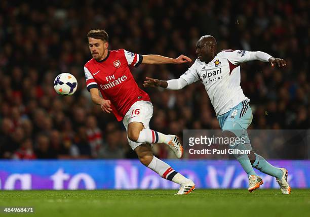 Aaron Ramsey of Arsenal is chased by Pablo Armero of West Ham United during the Barclays Premier League match between Arsenal and West Ham United at...