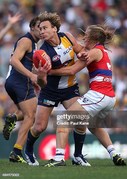 Matt Priddis of the Eagles looks to handball while being tackled by Roarke Smith of the Bulldogs during the round 21 AFL match between the West Coast...