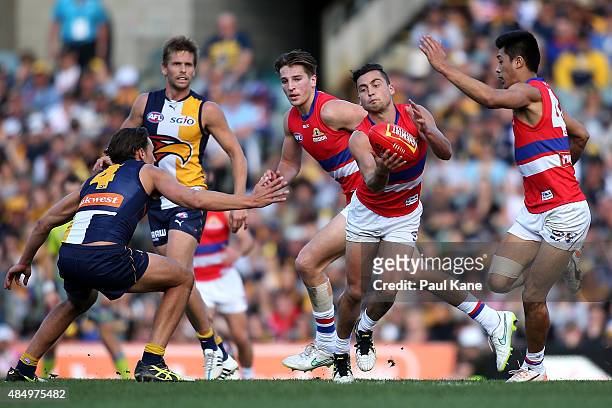 Luke Dahlhaus of the Bulldogs looks to handball during the round 21 AFL match between the West Coast Eagles and Western Bulldogs at Domain Stadium on...