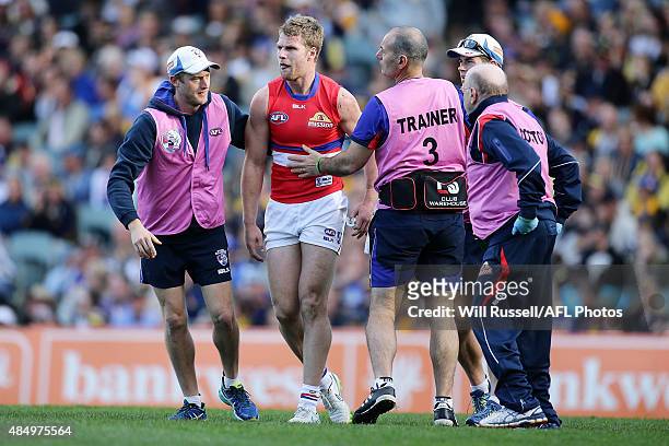 Jake Stringer of the Bulldogs is assisted off the field during the round 21 AFL match between the West Coast Eagles and Western Bulldogs at Domain...