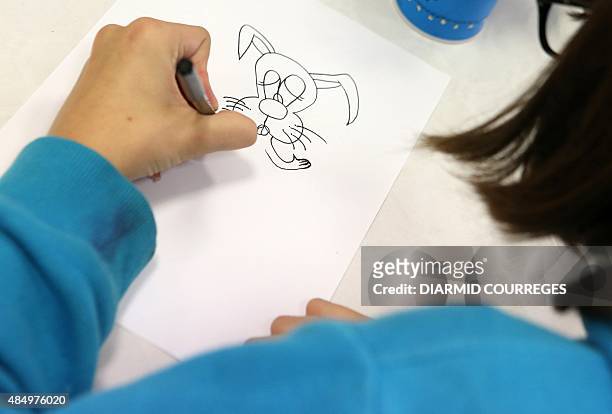 Child draws in the Salle du Pont du Buy in Brive-la Gaillarde, where writing and cooking workshops were organised and objets for the left-handed were...