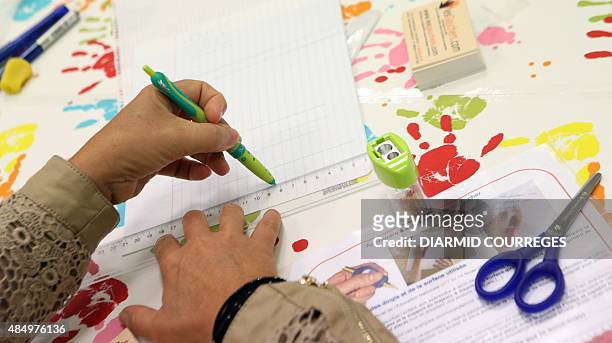 Person draws a lign with a ruler for left-handed users in the Salle du Pont du Buy in Brive-la Gaillarde, where writing and cooking workshops were...