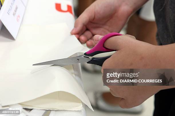 Person cuts paper with scissors for left-handed users in the Salle du Pont du Buy in Brive-la Gaillarde, where writing and cooking workshops were...