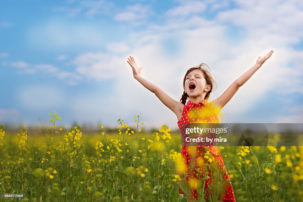 Joyful girl in blooming field