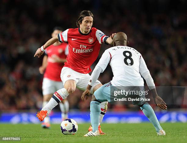 Tomas Rosicky of Arsenal takes on Pablo Armero of West Ham during the match between Arsenal and West Ham United in the Barclays Premier League at...