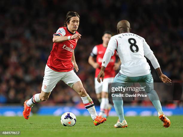 Tomas Rosicky of Arsenal takes on Pablo Armero of West Ham during the match between Arsenal and West Ham United in the Barclays Premier League at...
