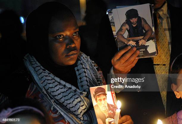 Palestinian woman lights a candle in a commemoration of the 3rd anniversary of Italian activist Vittoro Arrigoni's death at the Gaza port in Gaza...